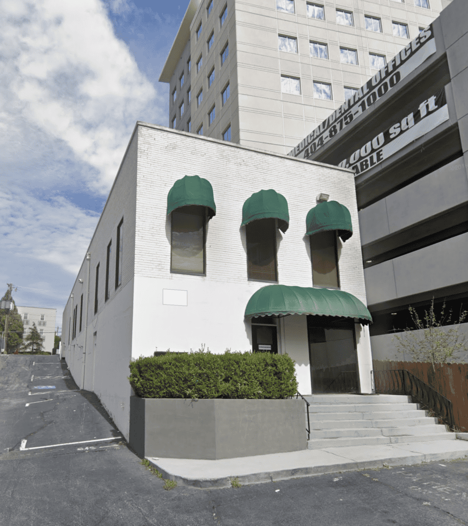 Atlanta restaurant real estate brokers office with green awnings and white exterior.