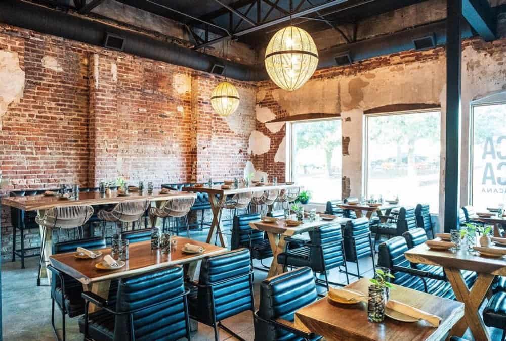 A restaurant with tables and chairs in a brick building.