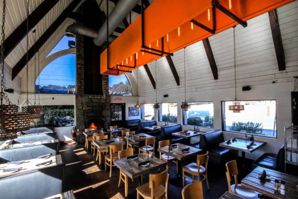Interior of a modern Atlanta restaurant with high vaulted ceilings and large windows.