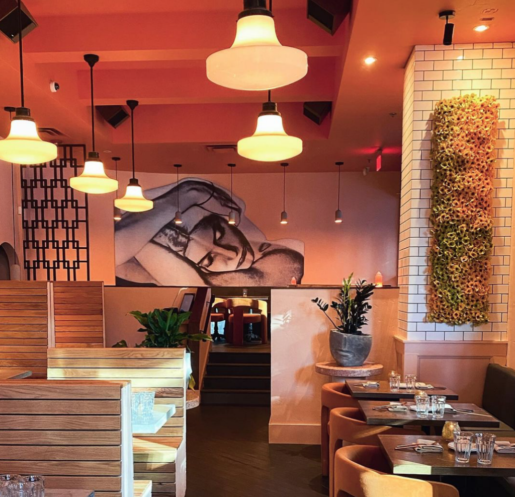 The interior of a restaurant with a mural on the wall.