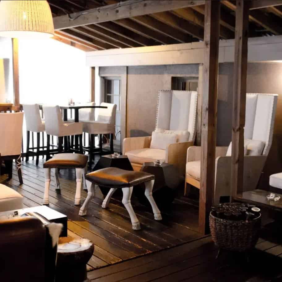 A living room with couches and chairs on a wooden deck.