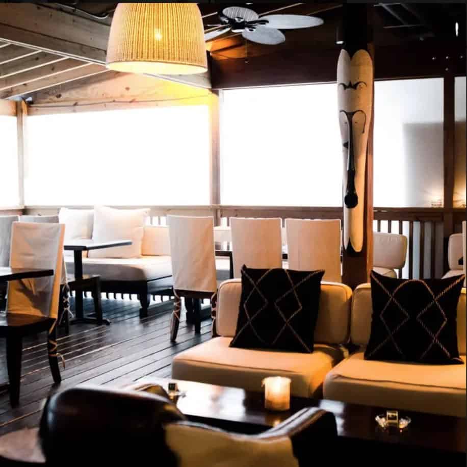 A restaurant with tables and chairs on a wooden deck.