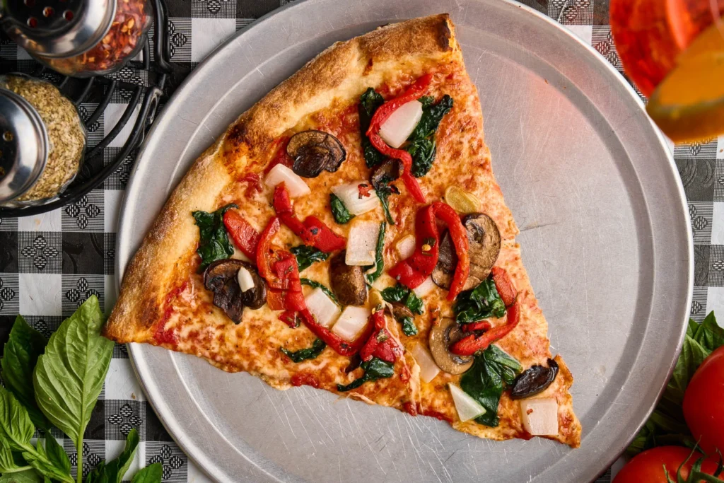 Delicious veggie pizza with peppers, mushrooms, spinach, and cheese, ideal for restaurant dining in.
