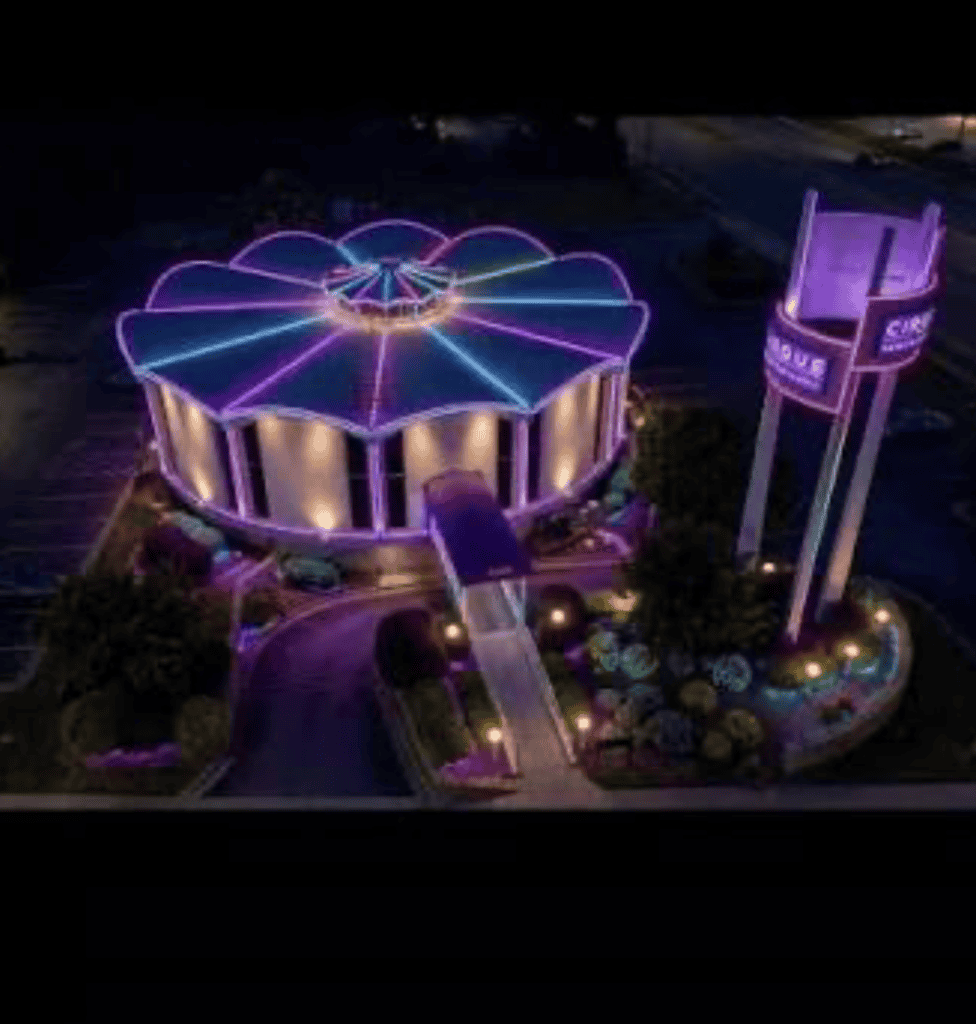 Night view of Atlanta amusement park with colorful neon lights and rides.