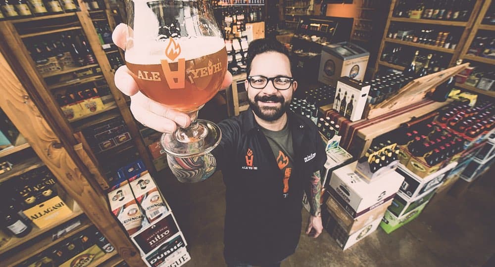 Man holding a beer in a wine shop, promoting Atlanta restaurant real estate services.