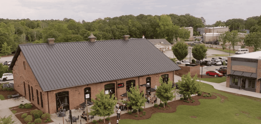 Exterior view of a historic brick restaurant building in Atlanta, surrounded by greenery and parking.