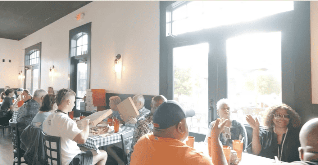 Interior view of a busy Atlanta restaurant with diverse customers enjoying meals.