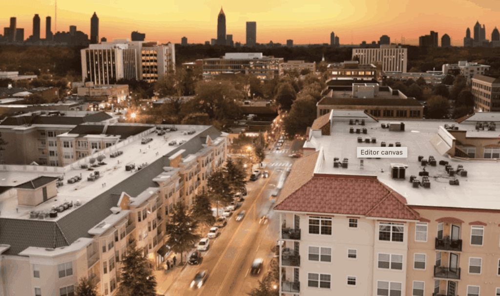 A cityscape at sunset showing a mix of mid-rise apartments, tree-lined streets, and a distant skyline with tall buildings.