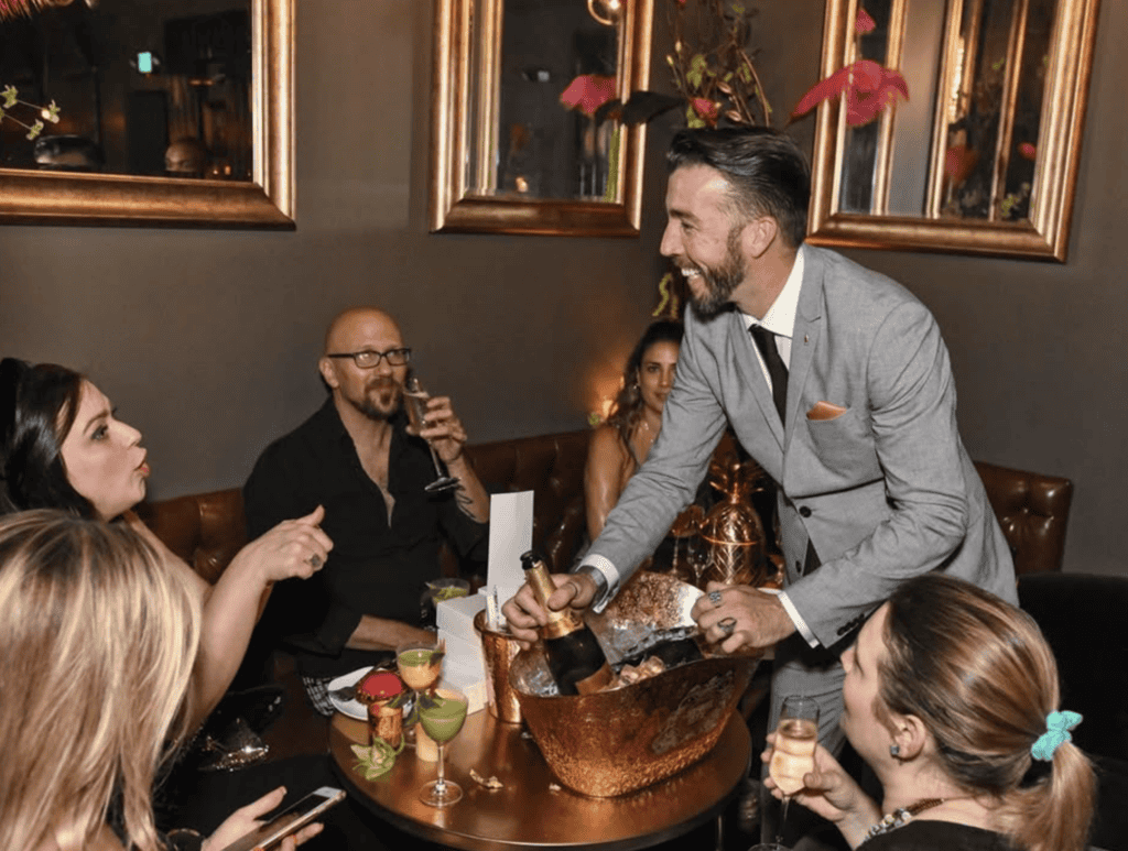 Elegant man serving champagne at a sophisticated restaurant gathering in Atlanta.