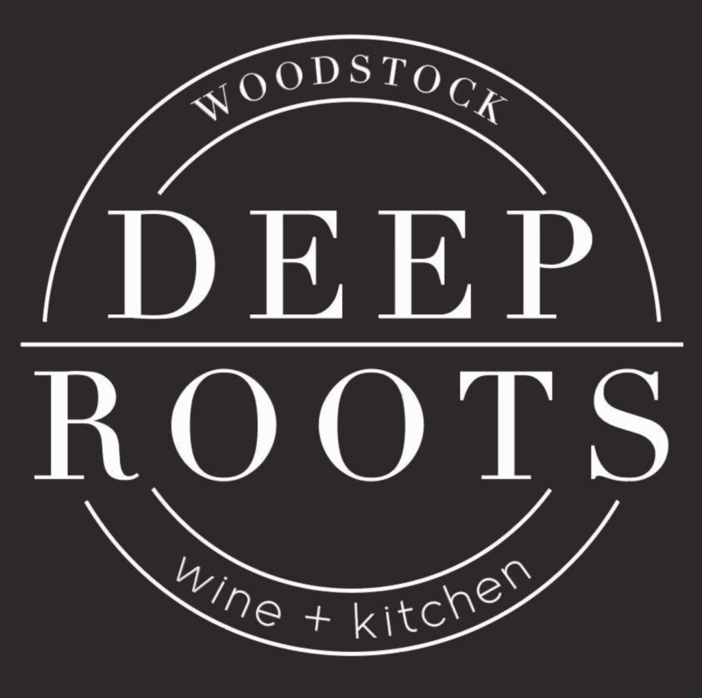 Black and white logo reading “WOODSTOCK DEEP ROOTS wine + kitchen” in bold and elegant text within a circular frame.
