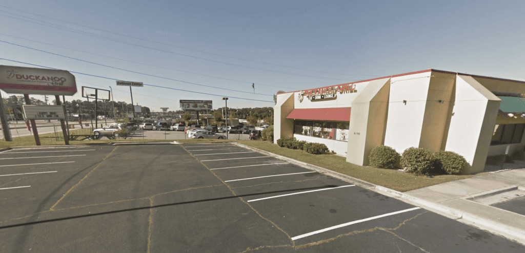 Atlanta restaurant real estate brokers office with parking lot and shopping center.