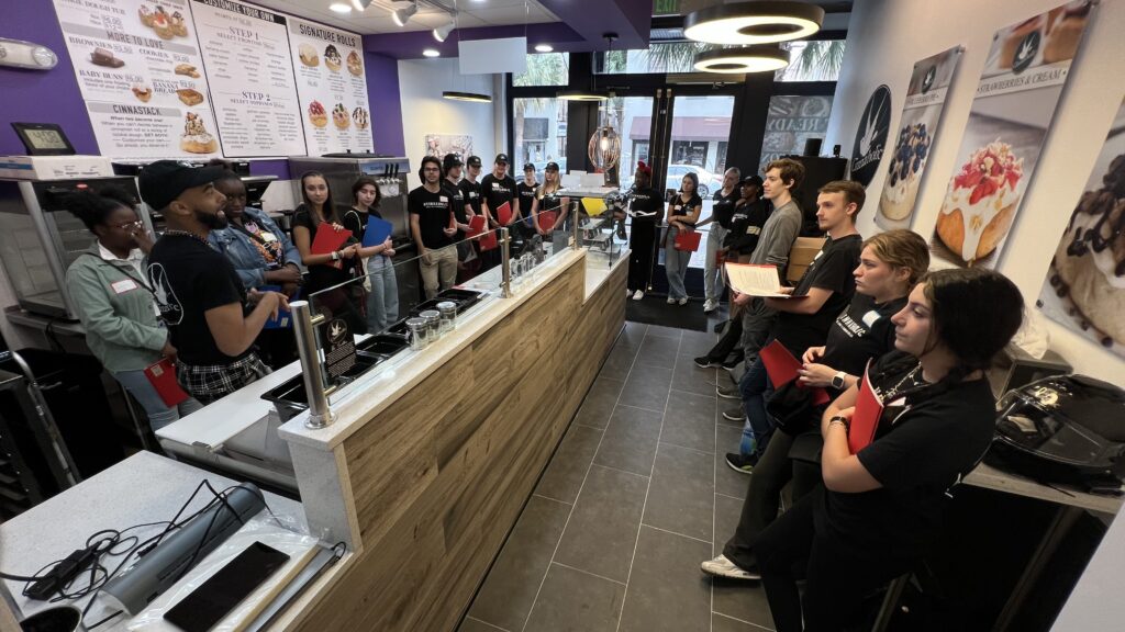 A group of people standing in line at a bakery.