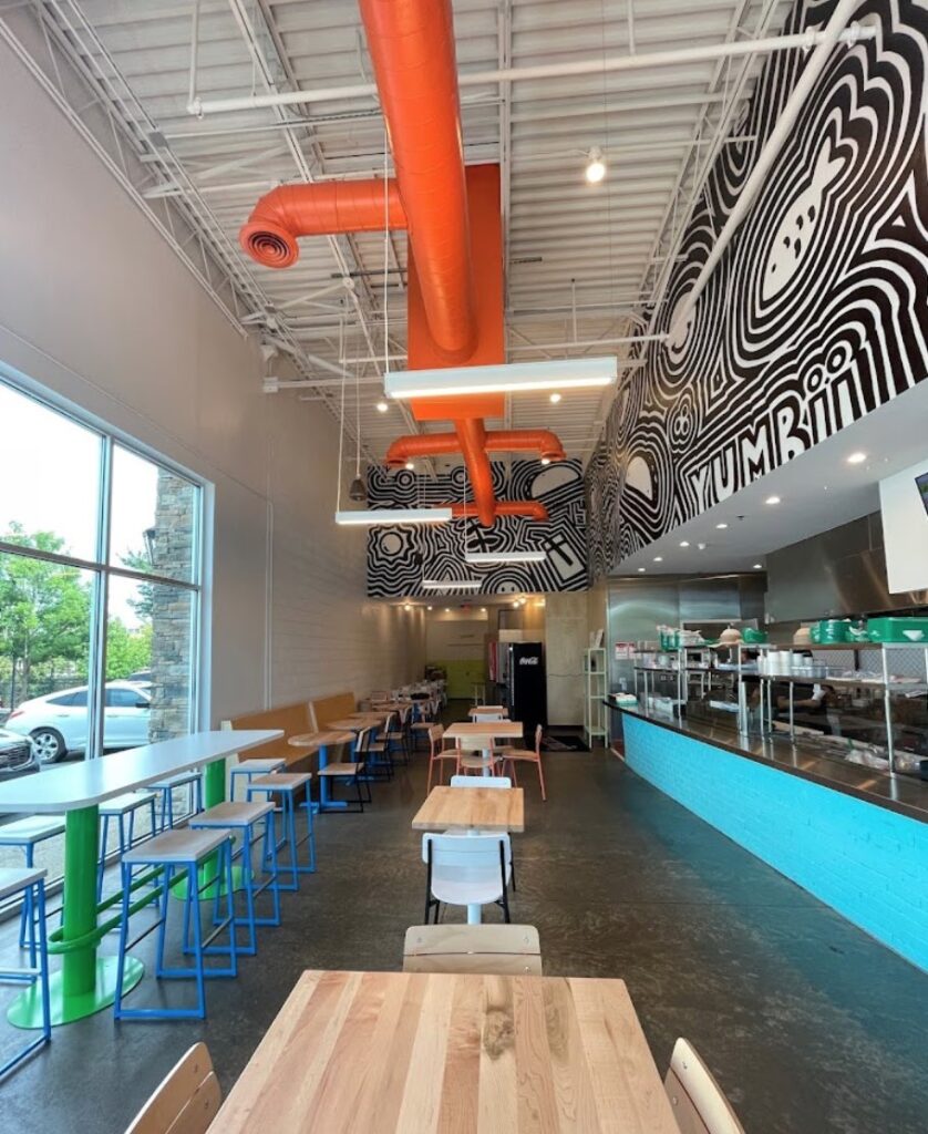 The inside of a restaurant with tables and chairs.