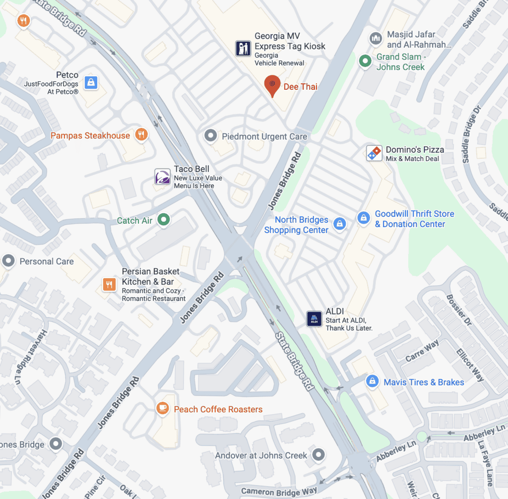 Map showing a section of Johns Creek, Georgia, with labeled businesses, shopping centers, roads, and major intersections. Notable spots include Dee Thai—a popular Johns Creek Thai Restaurant—ALDI, and Taco Bell.