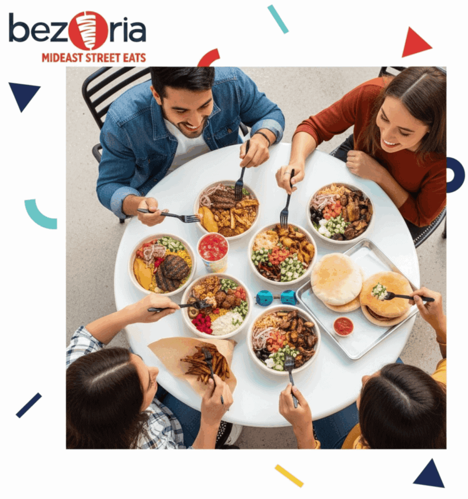 Diverse group enjoying Middle Eastern cuisine at a restaurant table in Atlanta.